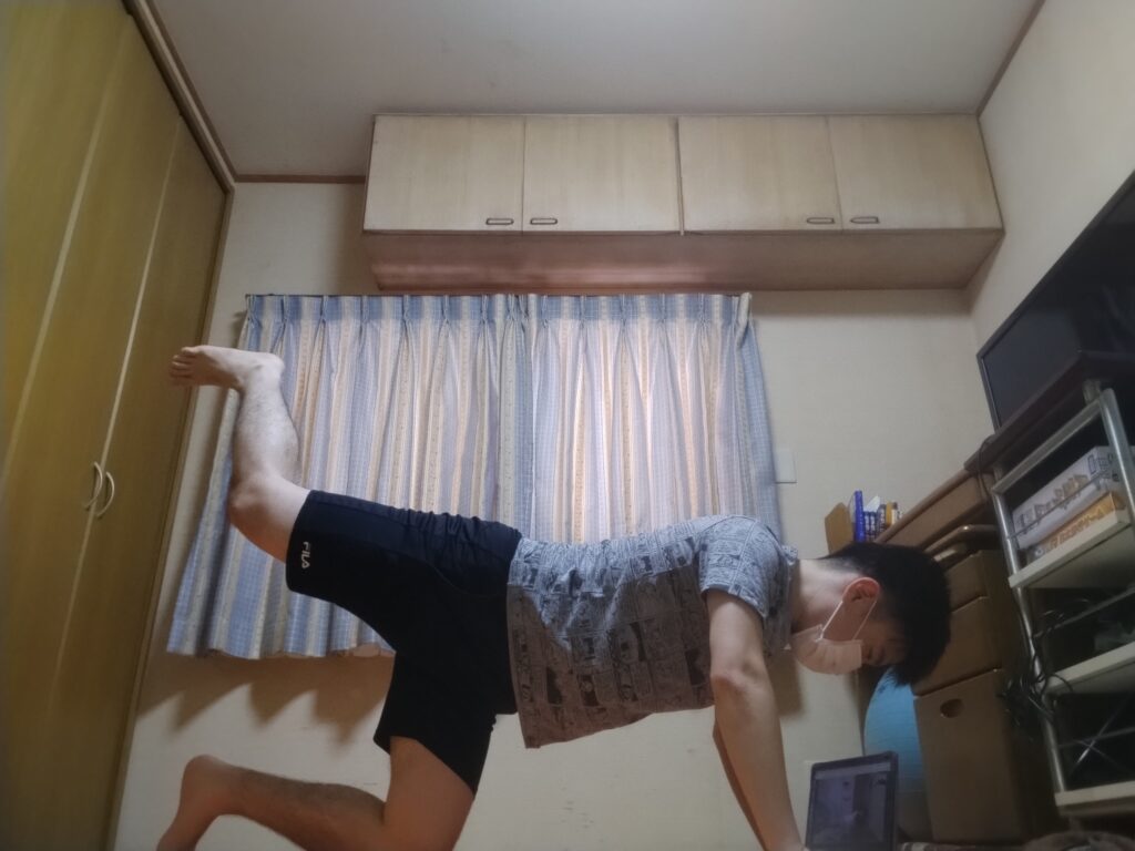 SOELUのレッスン中に四つ這いで片脚を上げてバランスをとる男性