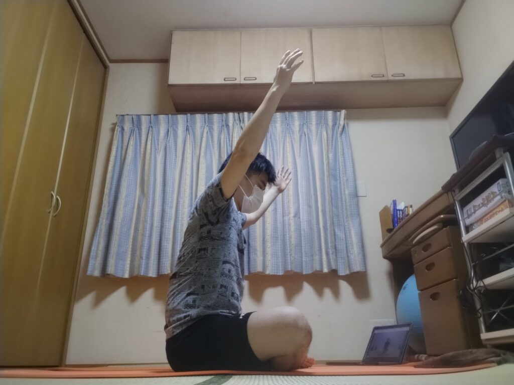 安楽座（Sukhasana）で両腕を頭上に伸ばして胸を開くストレッチポーズ