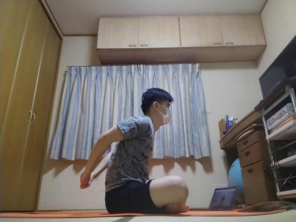 安楽座（Sukhasana）で両手を後ろで組み胸を開くストレッチポーズ