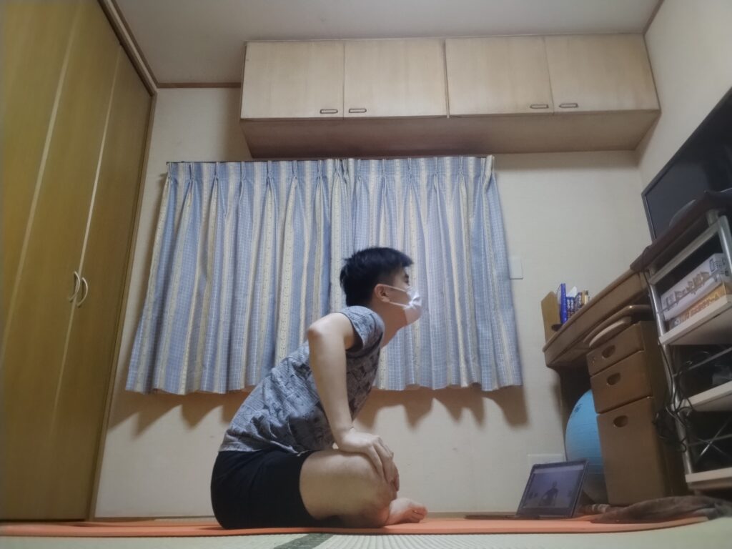 安楽座（Sukhasana）で胸を前に突き出して背中を反らすストレッチポーズ