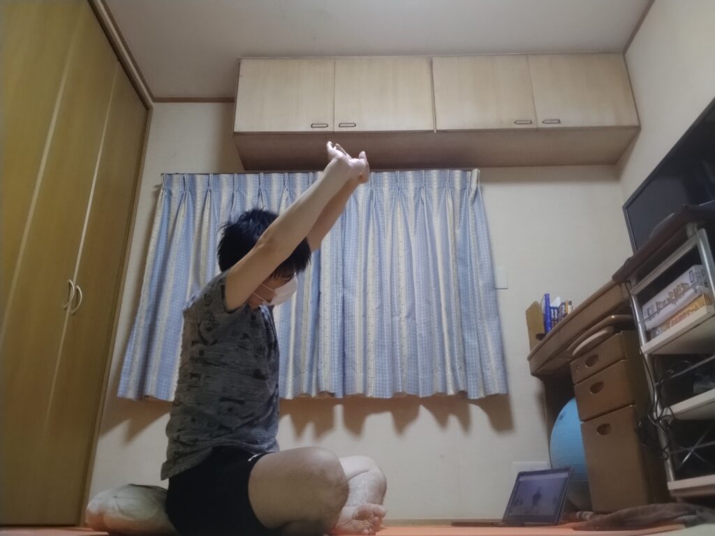 安楽座（Sukhasana）で両手を組んで頭上に伸ばすストレッチポーズ