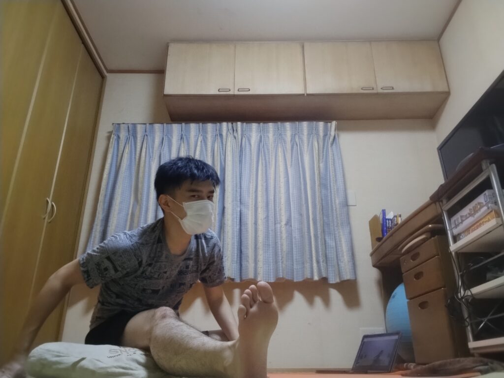 安楽座（Sukhasana）で上体を前に倒し腕を使って伸ばす前屈ポーズ