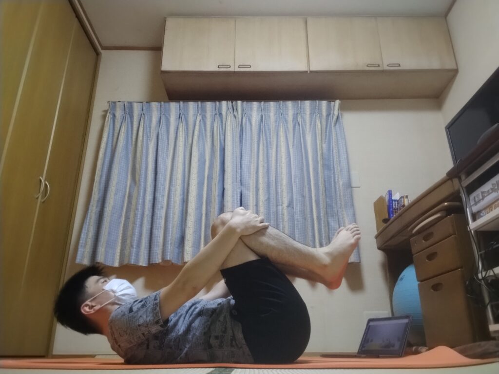 仰向けで両膝を抱えるガス抜きのポーズ