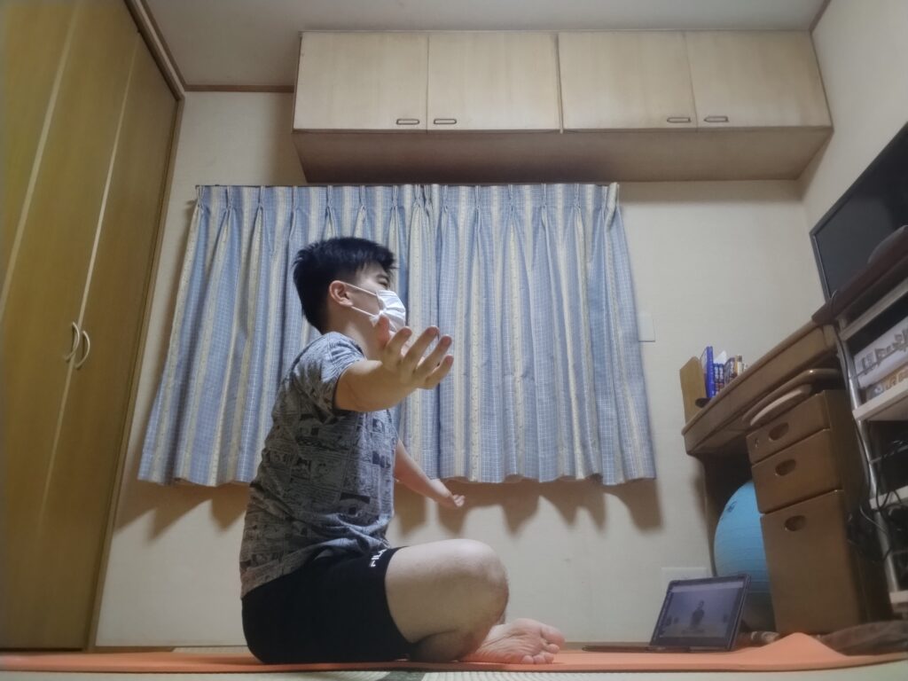 安楽座で両腕を左右に広げるポーズ