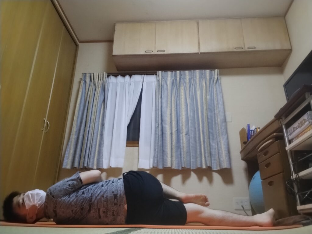 SOELUのヨガレッスンで背中と腰をねじるストレッチポーズを行っている様子。