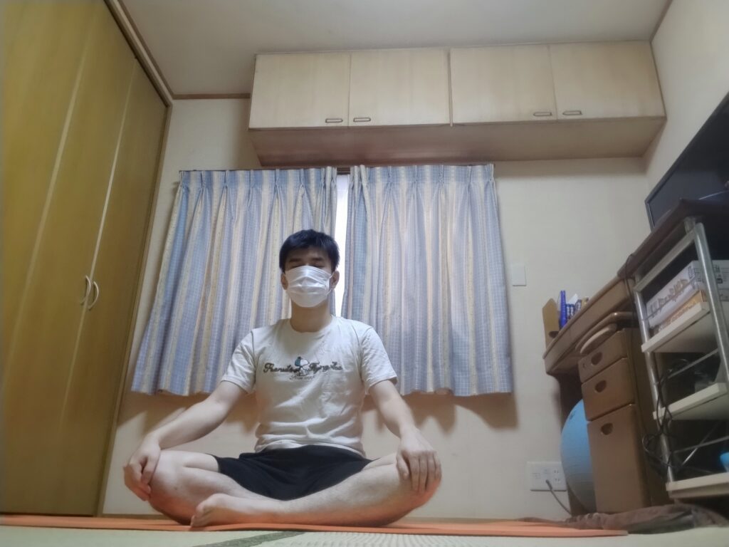 安楽座で目を閉じて呼吸を整える男性