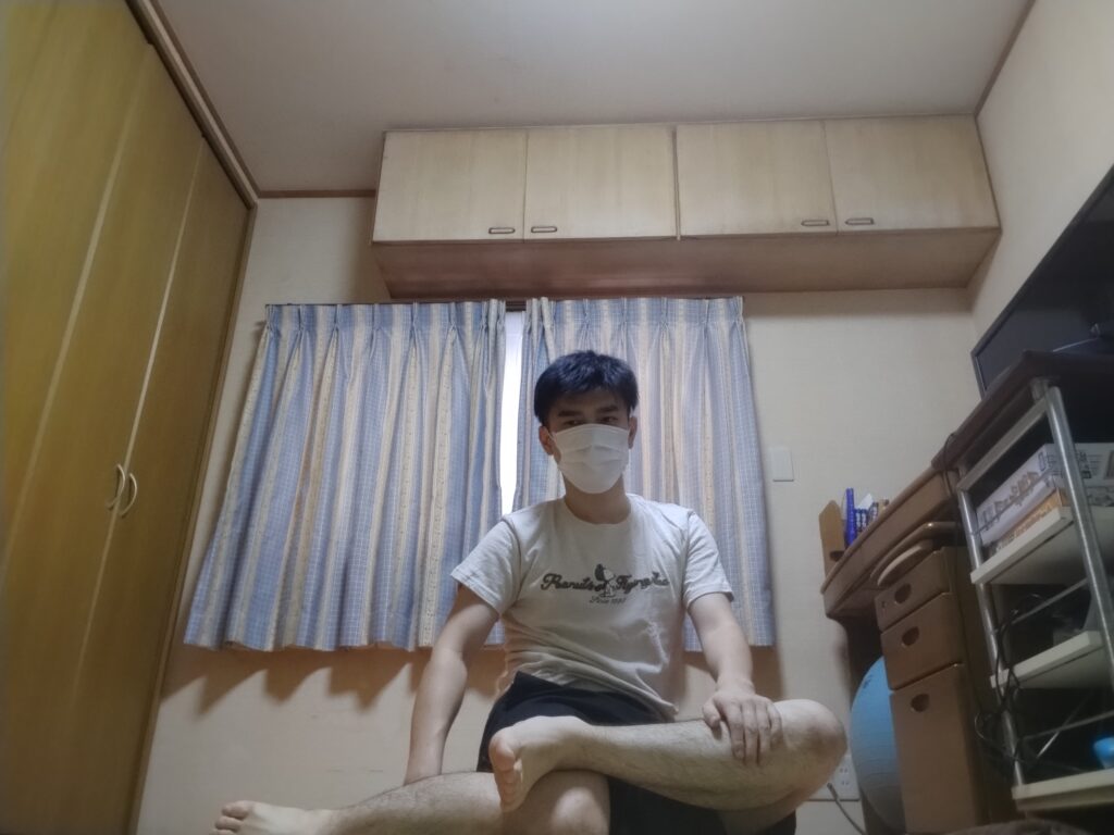 安楽座で足を深く組んで座る男性のヨガポーズ