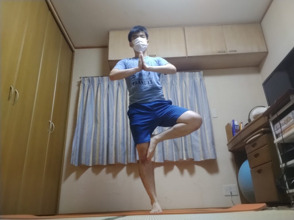 ツリーポーズを正面からとったヨガポーズの男性