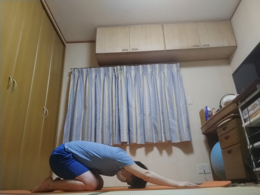 チャイルドポーズでリラックスする男性のヨガポーズ