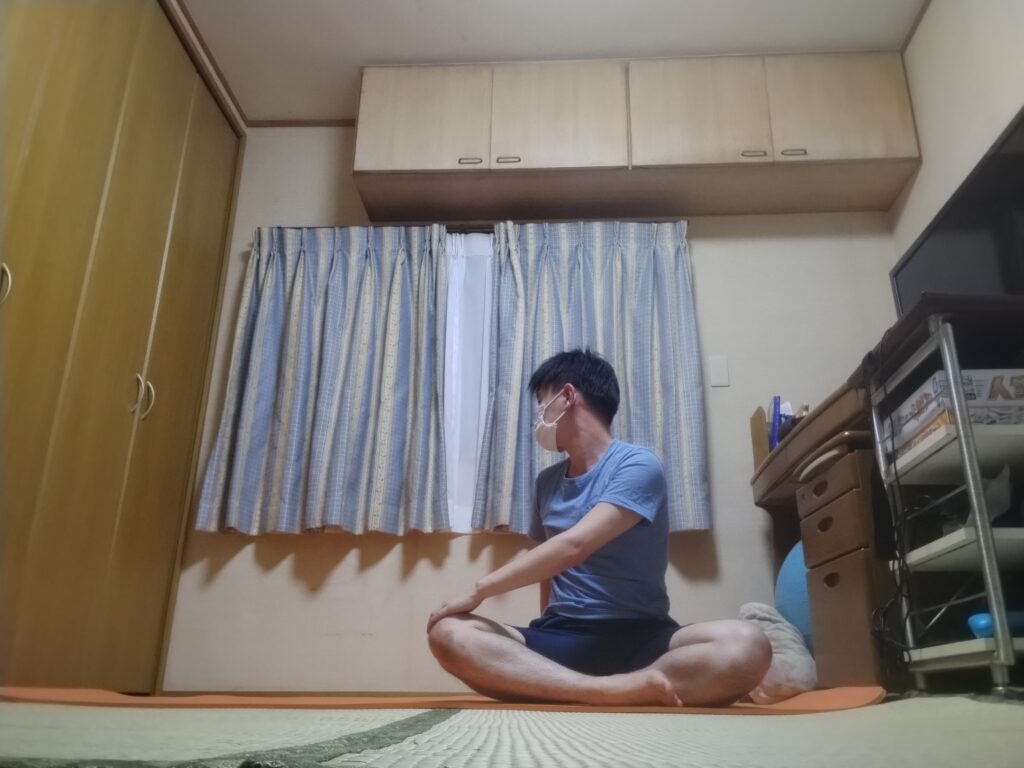 SOELUのオンラインヨガで座ったまま体をひねるツイストポーズを実践している様子