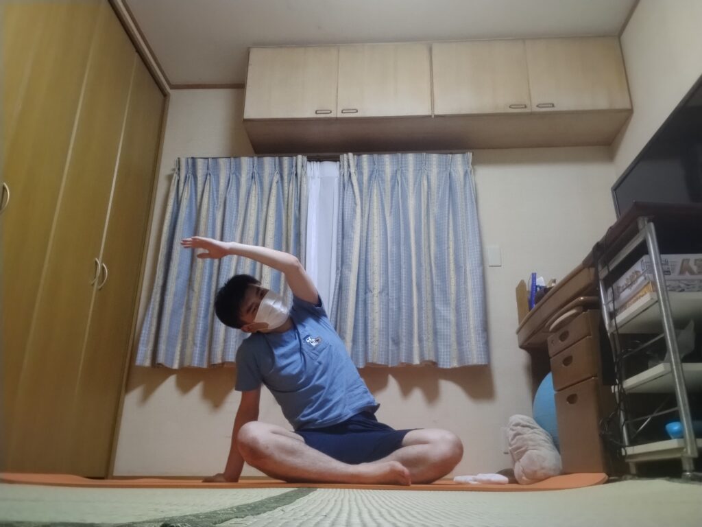 SOELUのオンラインヨガで座ったまま体を横に伸ばすサイドストレッチをしている様子
