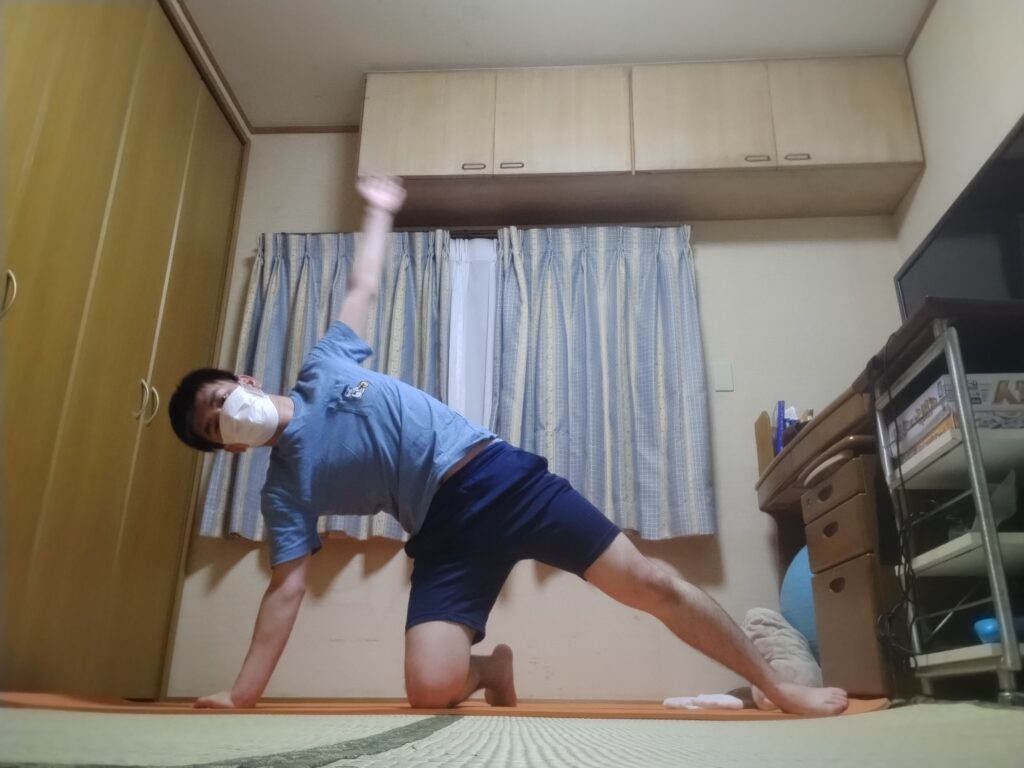 SOELUのオンラインヨガで片手を床につき体を横に伸ばすサイドプランクのバリエーションポーズをしている様子