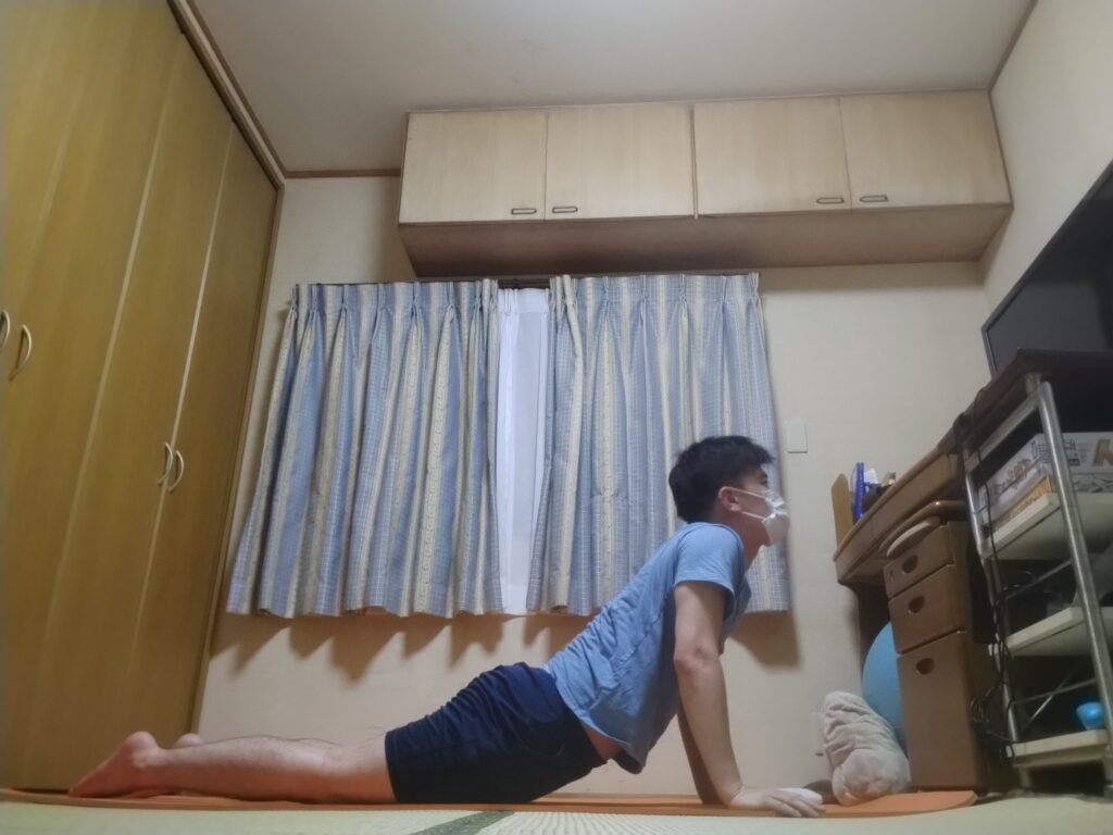 SOELUのオンラインヨガでコブラのポーズを行い、背筋を伸ばして胸を開いている様子