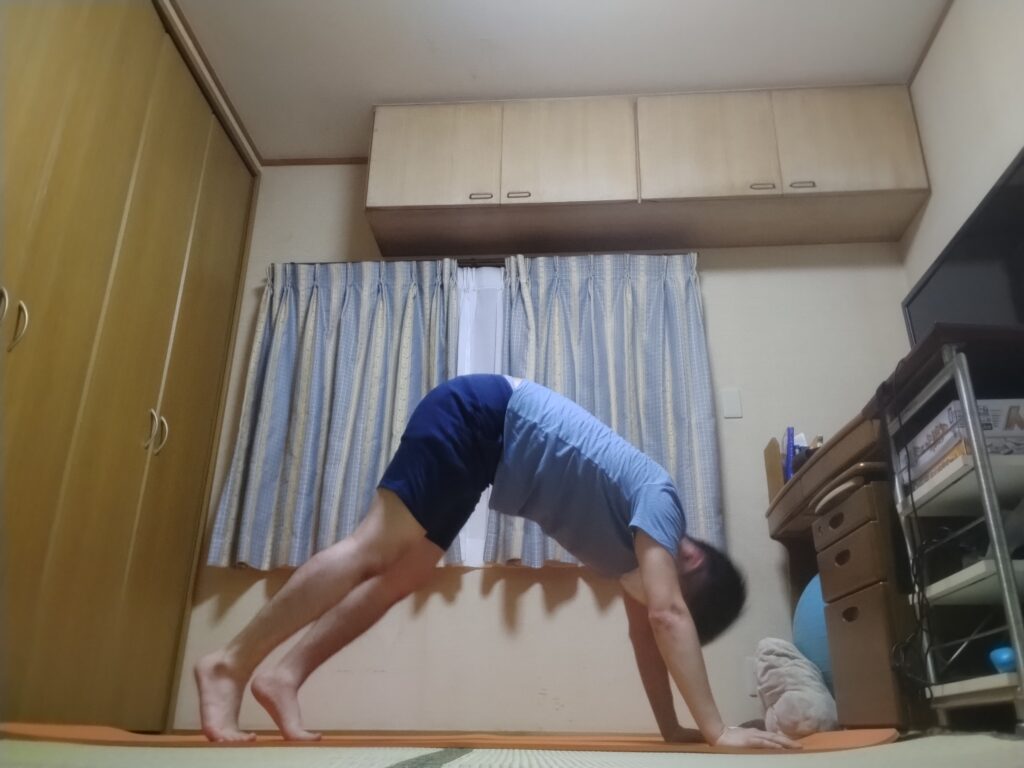 SOELUのオンラインヨガで下向きの犬のポーズ（ダウンドッグ）を行い、全身を伸ばしている様子