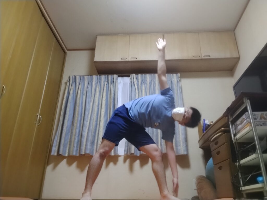 SOELUのオンラインヨガで三角のポーズを行い、体側を大きく伸ばしている様子